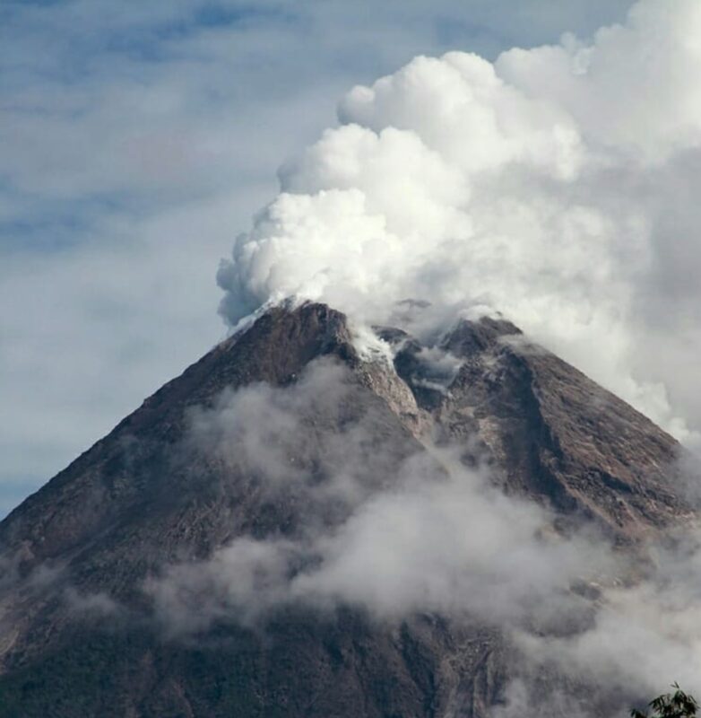 A mountain with smokes on top of it